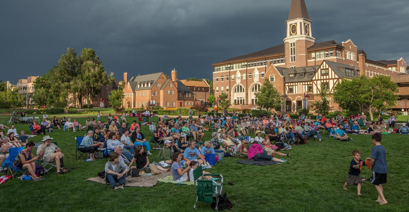 photo of community members sitting on campus grass